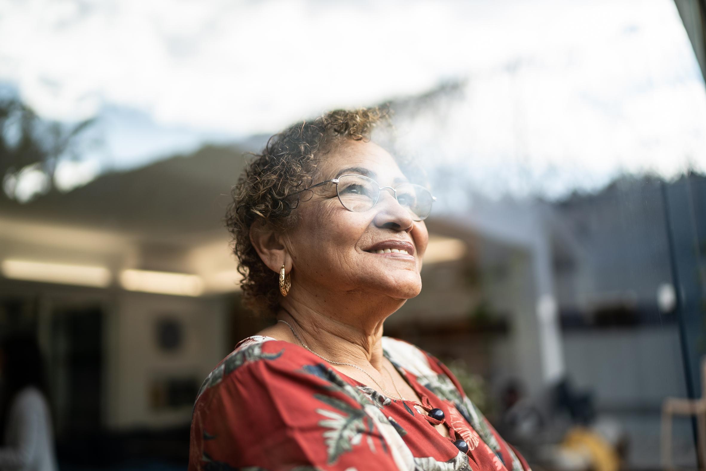 Woman gazes hopefully out of window