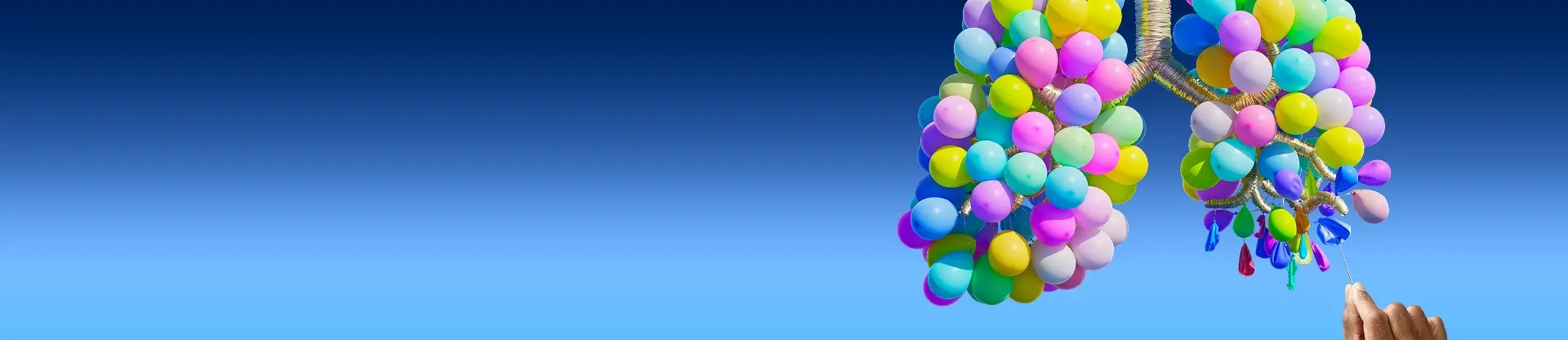 Lunge aus Luftballons auf blauem Hintergrund. Eine Hand, die eine Stecknadel hält, lässt mehrere Ballons am unteren Ende der rechten Lunge platzen. 