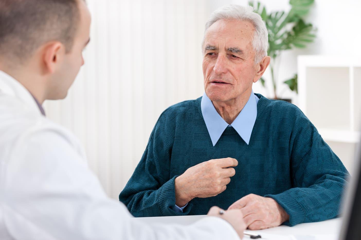 Un homme âgé assis en pleine consultation avec un médecin